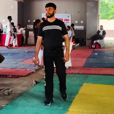 A candid moment at a Taekwondo tournament. My focus is always on my students and the path of the warrior, both in and out of the ring.