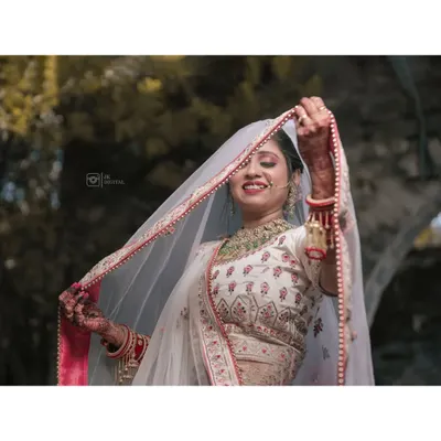 A joyful bridal portrait, with the bride lifting her veil to reveal a radiant smile, capturing her happiness and anticipation.