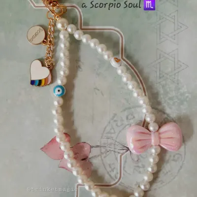 I loved bringing this custom bag charm to life for a Scorpio soul. It features a string of elegant pearls, a soft pink bow, a protective evil eye, and a rainbow heart, all telling a unique story.
