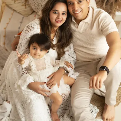 A classic family portrait, seated together in a cozy, boho-inspired studio setting. The coordinated white outfits create a timeless and serene look.