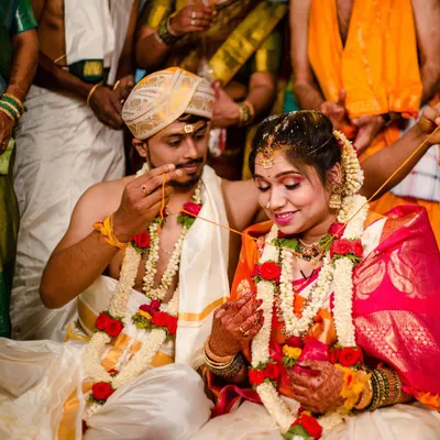 A candid moment during the thali tying ceremony. The bride's makeup is designed to be radiant and picture perfect from every angle, with a focus on traditional elements like the bindi and gold jewelry.
