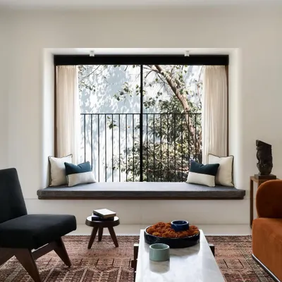 The main goal for this home was to blend it with its natural surroundings. This large bay window in the living room does just that, creating a comfortable seating nook that feels immersed in the trees.