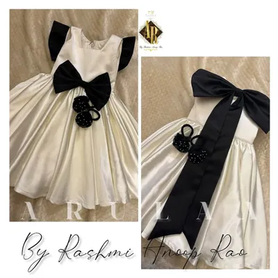 A birthday frock for our cutest client. This ecru satin dress is designed with a big black bow and comes with adorable matching handmade accessories.