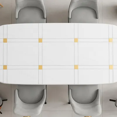 This top-down view shows the clean, geometric pattern of a modern dining table. The white surface is accented with gold-finished squares, creating a look of understated luxury. Paired with soft grey upholstered chairs, this set is perfect for a contemporary dining space.
