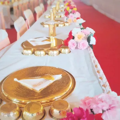 A close-up of the traditional Rajasthani-style golden thali set. The hammered texture of the plate and bowls adds a touch of royal elegance to the dining experience.