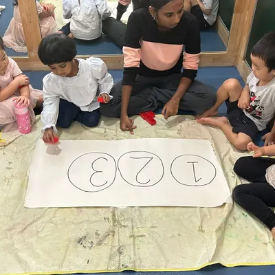 A teacher guides a group of children in a number recognition activity. Using hands-on materials makes learning to count from 1 to 3 a fun game.