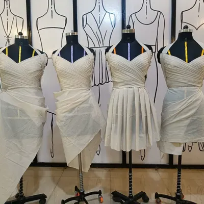 A lineup of student work from our draping class. Each mannequin showcases a different style, from pleated bodices to wrapped skirts, all created with muslin.