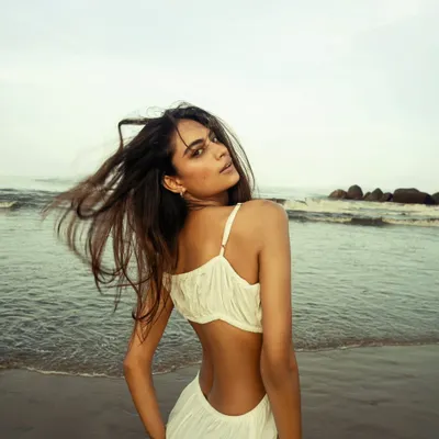 Capturing the effortless beauty of a model on the beach. The wind in her hair and the soft, natural light create a feeling of freedom and serenity.