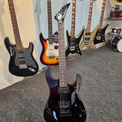 A lineup of shred machines. The Jackson JS11 in black takes center stage, surrounded by other high-performance models ready for fast riffs and heavy tones.