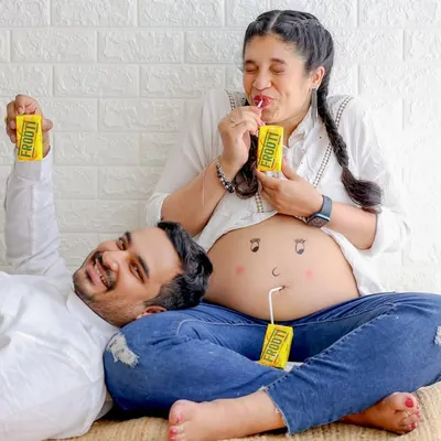 A fun and playful shot of an expecting couple. This casual style, with jeans and simple tops, is perfect for capturing your authentic personalities.