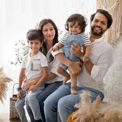 A picture perfect family of four. The coordinated white and denim outfits give this portrait a fresh, clean, and cohesive look in my boho studio.