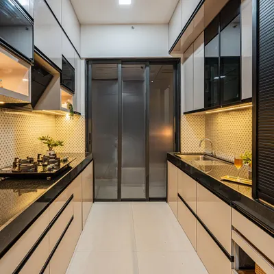 This is a parallel kitchen layout I designed for maximum efficiency. The glossy, handleless cabinets in a dual-tone finish give it a sleek, modern look, while the under-cabinet lighting provides excellent task lighting.