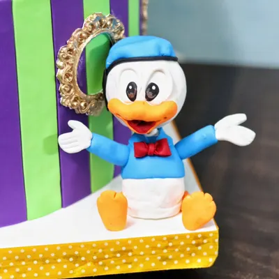 A cheerful Donald Duck figurine, part of a larger Disney-themed cake. I teach how to capture the classic look of these beloved characters.