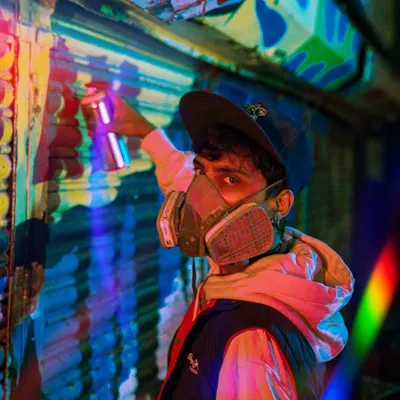 Me in my gear, respirator on, ready to paint. The bright, colorful lighting in this shot captures the energy I feel when I'm about to start a new piece.