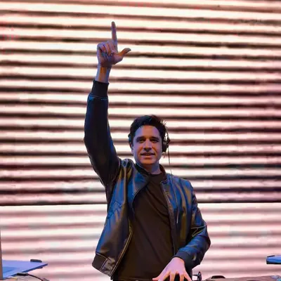 In the zone behind the decks, with my hand up, feeling the energy of the crowd. This is my happy place, where I connect with the music and the people.