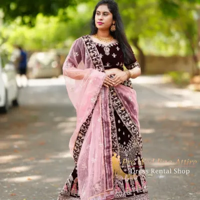 This is a full view of my dark velvet lehenga, which features intricate doli and baraat embroidery along the border. It's paired with a contrasting light pink net dupatta for a balanced look.
