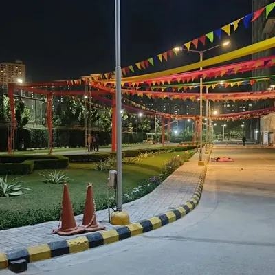 For a festive outdoor event at night, I installed these colorful fabric streamers and flags across the venue. The overhead decorations, combined with street lighting, create a lively and celebratory mood for guests.