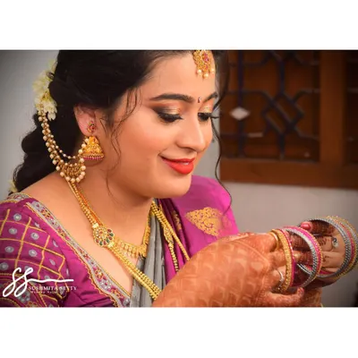 A candid moment of the beautiful bride getting ready. This simple and elegant engagement makeup features a soft smokey eye and a classic red lip that looks stunning with her jewelry.