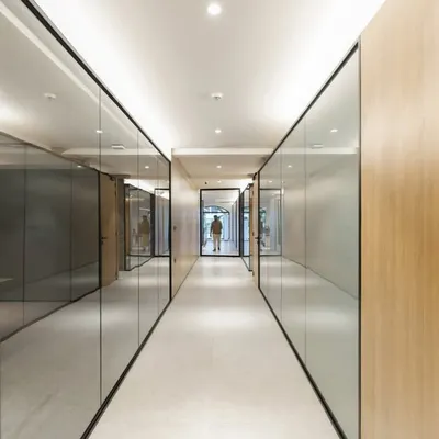 For a high-intensity infrastructure company, we designed a workspace that brings a sense of calm and order. The corridor uses reflective glass and clean wood paneling to create a streamlined path, reinforcing a feeling of clarity and purpose amidst a complex business environment.
