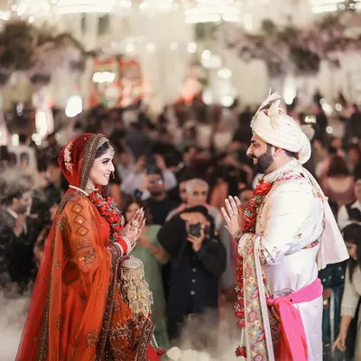 The Jaimala ceremony, a moment of joy, anticipation, and gentle teasing. I capture this pivotal moment with a focus on the couple's expressions and the energy of the crowd.
