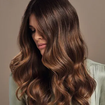 This is a perfect example of a rich, multi-tonal brunette. The soft waves showcase the seamless blend of deeper roots and lighter, warmer ends, creating a look of effortless elegance and healthy shine.