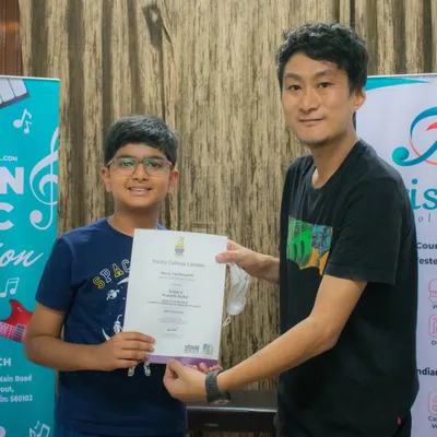 A moment of achievement as our student receives his Trinity College London grade exam certificate. We guide students through the entire certification process.