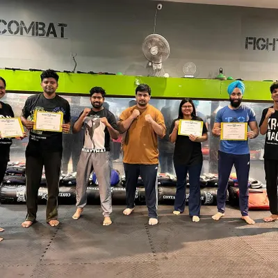 A group of students proudly holding their certificates after successfully passing their level test. Each certificate is earned through sweat, dedication, and a demonstration of practical skill.