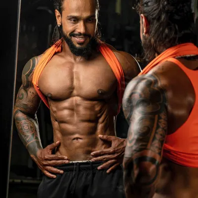 Admiring the progress in the mirror. This is a moment of satisfaction that comes after months of hard work and dedication to the craft of bodybuilding.