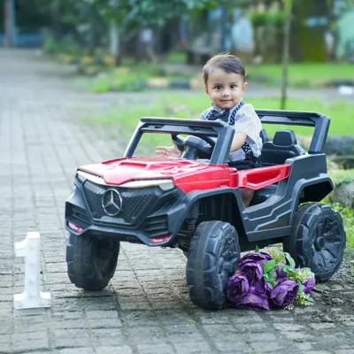 Ready to ride into his first birthday celebration. This little prince looks adorable in a toy jeep, a fun and dynamic prop for a first birthday shoot.