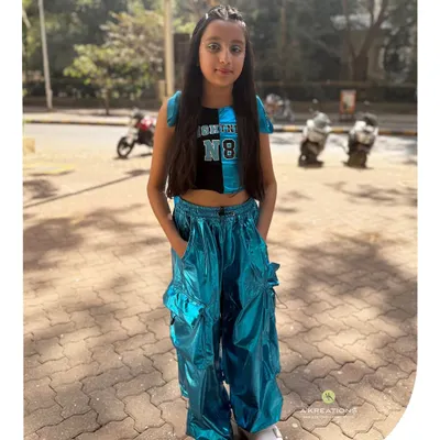 This young client is rocking her full look, with trendy braids, hair tinsel, and subtle face gems for a fun, party-ready style.