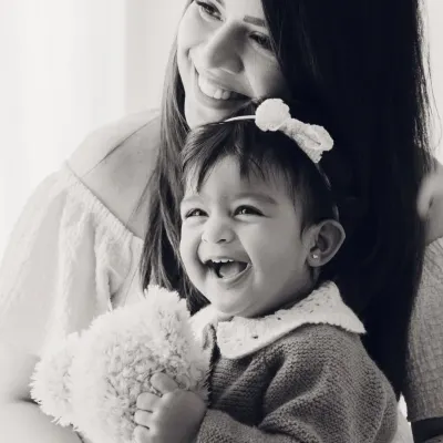 The pure joy between a mother and her child, captured in a classic black and white portrait. Her laugh is absolutely radiant.