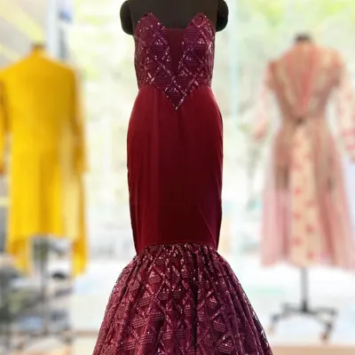 This custom corset bodice ball gown in a deep maroon is pure red carpet glamour. The structured bodice features intricate sequin work, while the mermaid-style skirt adds drama and sophistication.