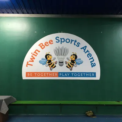 The completed logo mural for 'Twin Bee Sports Arena', a badminton court in Bangalore. We painted their brand identity, including the mascot and tagline, to create a welcoming and professional look for their facility.