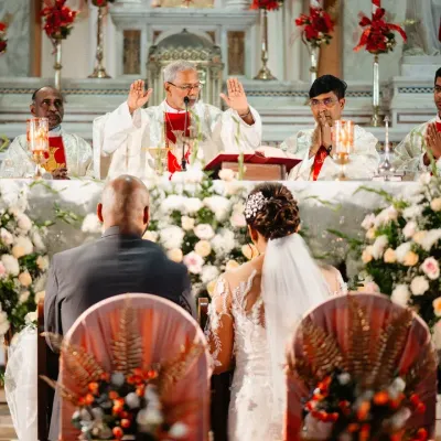 The priest gives his blessing to the couple during a beautiful Catholic wedding ceremony. I position myself to capture the solemnity of the moment and the grandeur of the church.