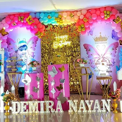 This grand butterfly-themed birthday is one of my favorites, featuring a gold sequin backdrop, large butterfly wing props, and a colorful balloon arrangement for a truly spectacular celebration.