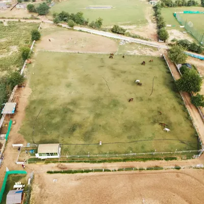 An aerial drone shot of my entire property, showing the main riding field, the practice arena, and the surrounding natural landscape.