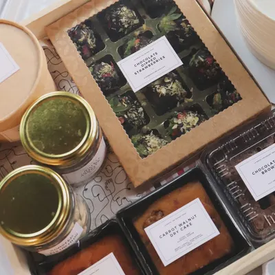 A look inside one of my custom wooden tray hampers. This one includes dry cakes, brownies, chocolate-dipped strawberries, and jars of snacks.