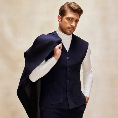 Here I've styled a tailored corduroy suit for ultimate sophistication. The navy vest and trousers are layered over a white turtleneck, with the matching trench coat draped over the shoulder for a look of effortless elegance.