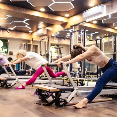 This is the focus and synchronicity of a group reformer class. Each client is engaged in a deep stretch, working at their own level to improve flexibility and strength.