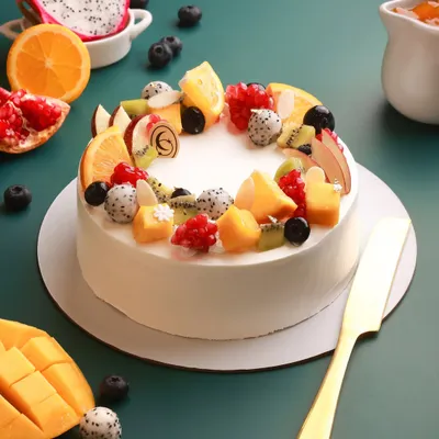 Our Summer Fruit Cake is a celebration of freshness. We layer light, fluffy cake with silky custard cream and top it with a vibrant assortment of seasonal fruits like mango, dragon fruit, and berries.