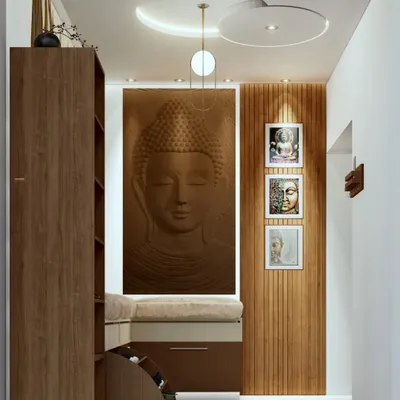 A foyer design for a home in Mysore's Police Layout, featuring a serene Buddha relief panel, a cushioned seating bench with built-in shoe storage, and elegant false ceiling lights.