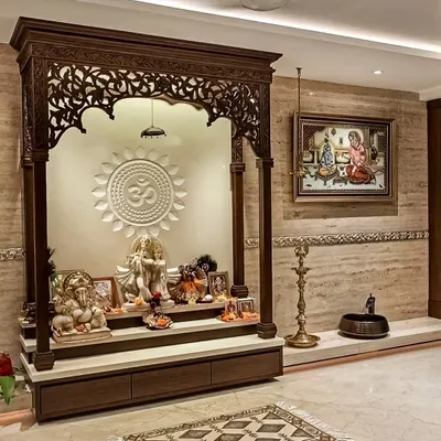 A magnificent, traditional pooja mandir crafted from dark wood with intricate carvings. This freestanding unit features a raised platform, storage drawers, and a beautifully detailed arch, creating a grand and sacred space.