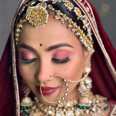 A close-up of my royal Marwadi bride. The focus here is on the rich, rosy eyeshadow and deep red lip, which perfectly complements her traditional jewellery and attire.