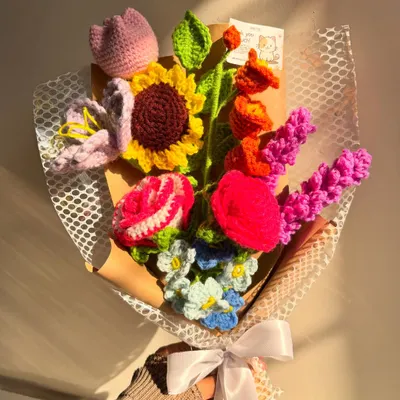 A stunning and colorful mixed bouquet, featuring a sunflower, rose, tulip, and other beautiful blooms, captured in the warm glow of the sun.