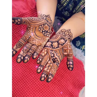 A beautiful, bold design with paisley and floral motifs, showing a rich, dark henna stain.