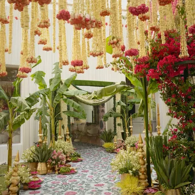 This stunning entrance walkway is designed for a traditional South Indian wedding. I used hanging garlands of tuberose and marigolds, flanked by banana trees and brass pots, to create a festive and auspicious welcome for guests.