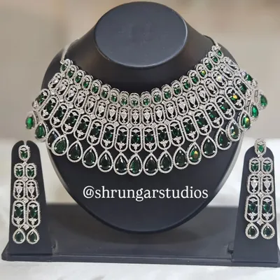 This stunning silver-finish American Diamond necklace with emerald green stones makes a bold statement. It's perfect for a reception or cocktail party.