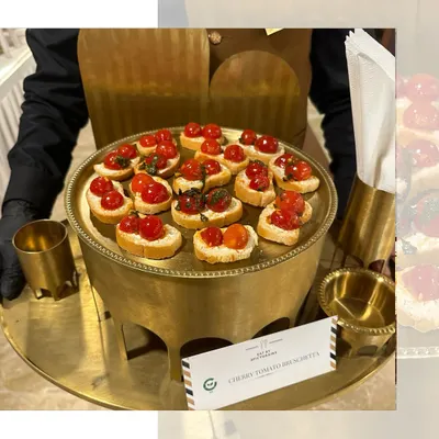 A classic Italian appetizer with a fresh twist. Our Cherry Tomato Bruschetta features ripe tomatoes and fresh basil on a toasted baguette, served elegantly on a brass platter. A simple, yet always popular, choice.
