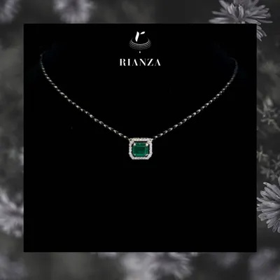 A modern take on a traditional symbol, this mangalsutra features a precious emerald gemstone surrounded by a halo of diamonds. It is designed for the contemporary bride who wants to stand out.