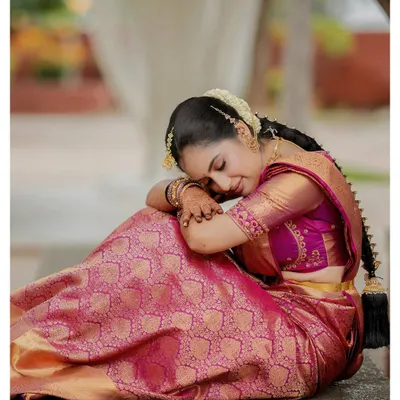 A moment of quiet contemplation for the bride. This artistic portrait in her beautiful pink Kanjeevaram saree captures a sense of peace and grace before the ceremony.